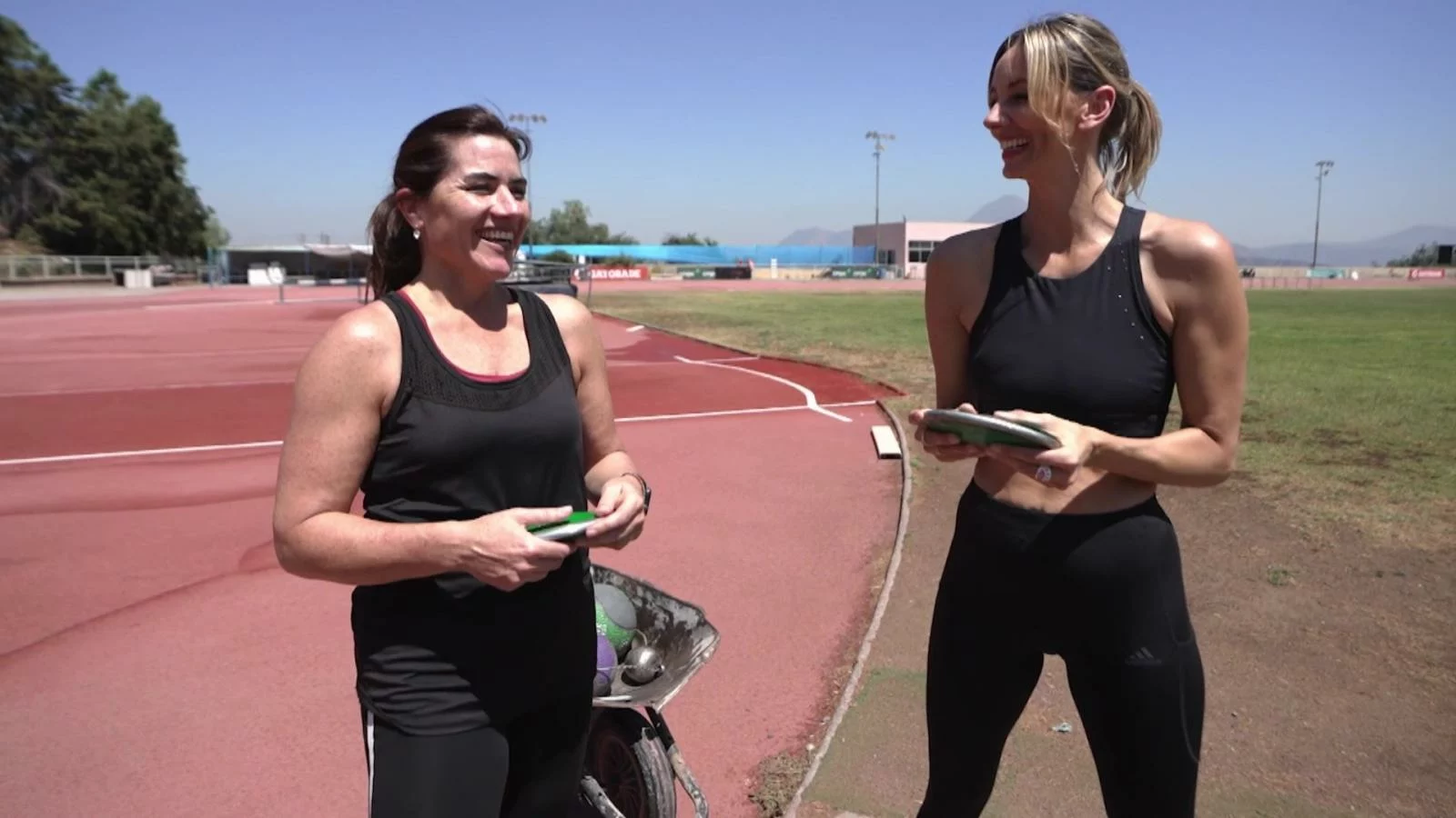 Bárbara Lewin conversando en una pista de atletismo
